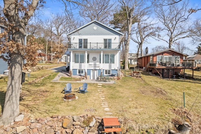 E13609 Idlewild Rd, Merrimac, WI 53561 - back of property featuring a balcony, a fire pit, a deck, and a lawn