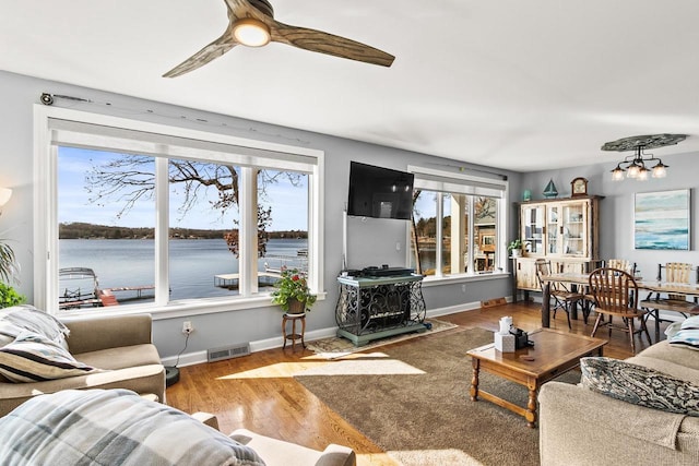 E13609 Idlewild Rd, Merrimac, WI 53561 - living room with baseboards, visible vents, wood finished floors, and ceiling fan with notable chandelier