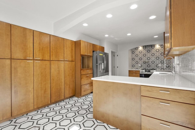 1203 Hewitt St, Neenah, WI 54956 - kitchen with oven, a sink, stainless steel fridge, a peninsula, and decorative backsplash