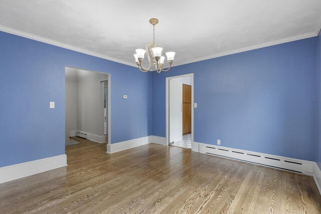 1203 Hewitt St, Neenah, WI 54956 - empty room featuring a baseboard heating unit, an inviting chandelier, wood finished floors, and ornamental molding
