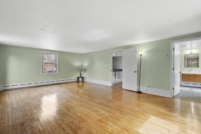 1203 Hewitt St, Neenah, WI 54956 - unfurnished room featuring a baseboard heating unit, wood-type flooring, and baseboards