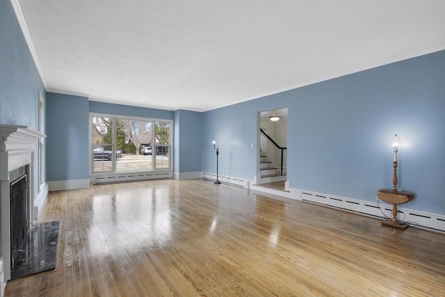 1203 Hewitt St, Neenah, WI 54956 - unfurnished living room with a fireplace, stairs, a baseboard heating unit, and wood finished floors