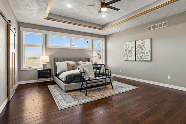3814 W Fieldwood Dr, Janesville, WI 53545 - bedroom with hardwood / wood-style floors, a barn door, visible vents, and a tray ceiling