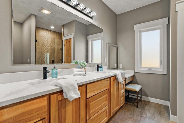 3814 W Fieldwood Dr, Janesville, WI 53545 - bathroom featuring a sink, a stall shower, baseboards, and double vanity
