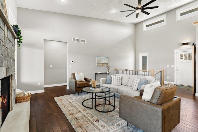 3814 W Fieldwood Dr, Janesville, WI 53545 - living room with a stone fireplace, dark wood-style floors, a ceiling fan, and visible vents