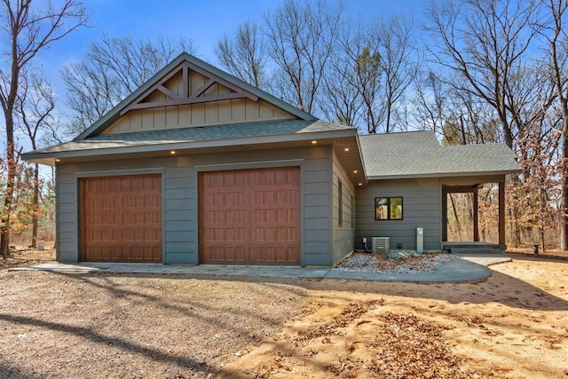 1644 Kingswood Trl, Nekoosa, WI 54457 - view of front facade featuring roof with shingles, a garage, central AC unit, and board and batten siding