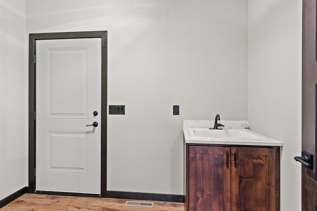 1644 Kingswood Trl, Nekoosa, WI 54457 - laundry room featuring a sink, light wood-type flooring, and baseboards