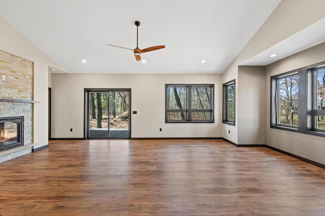 1644 Kingswood Trl, Nekoosa, WI 54457 - unfurnished living room featuring lofted ceiling, wood finished floors, a ceiling fan, a fireplace, and baseboards