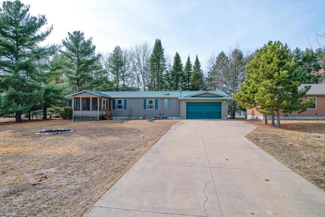 N7957 15th Ave, New Lisbon, WI 53950 - view of front of home featuring an attached garage, metal roof, driveway, and a sunroom