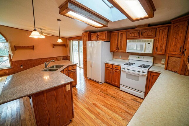 N7957 15th Ave, New Lisbon, WI 53950 - kitchen with white appliances, brown cabinetry, light wood finished floors, a sink, and pendant lighting