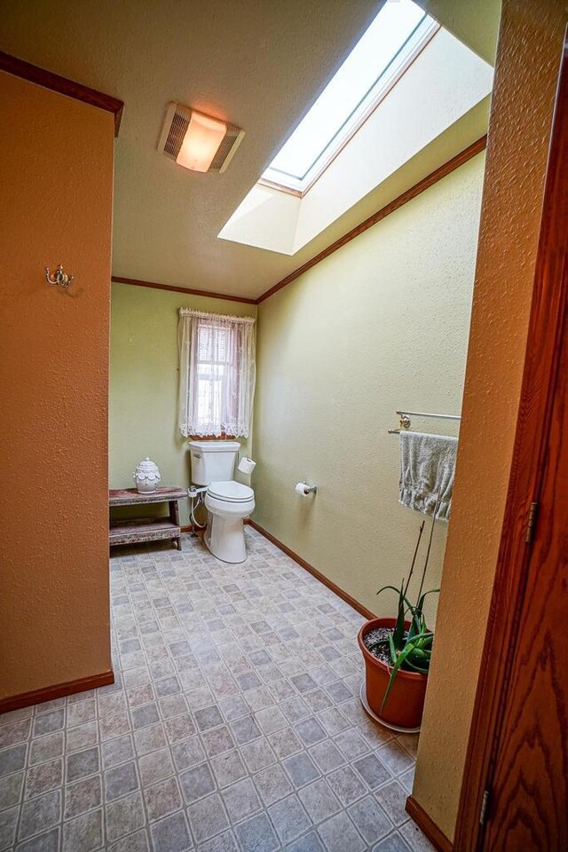 N7957 15th Ave, New Lisbon, WI 53950 - bathroom with visible vents, baseboards, a skylight, ornamental molding, and toilet