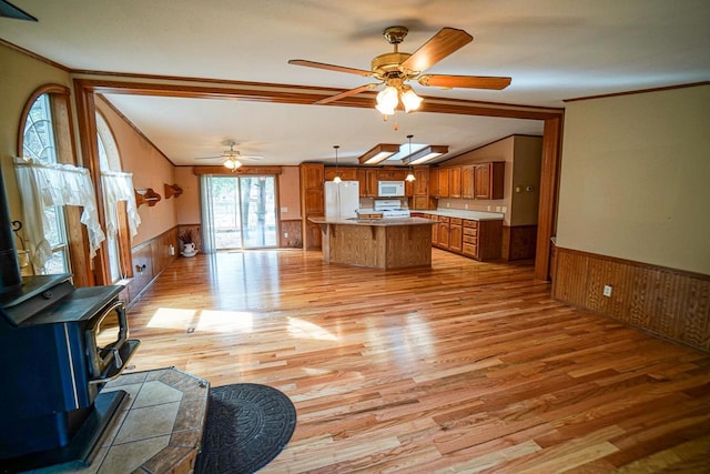 N7957 15th Ave, New Lisbon, WI 53950 - kitchen featuring white appliances, a wood stove, a ceiling fan, and wainscoting
