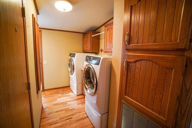 N7957 15th Ave, New Lisbon, WI 53950 - laundry room featuring light wood finished floors, baseboards, washing machine and dryer, ornamental molding, and cabinet space