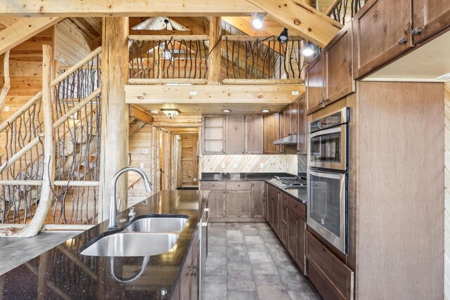10728 Spring St, Mount Pleasant, WI 53177 - kitchen with wooden walls, under cabinet range hood, a high ceiling, stainless steel appliances, and a sink