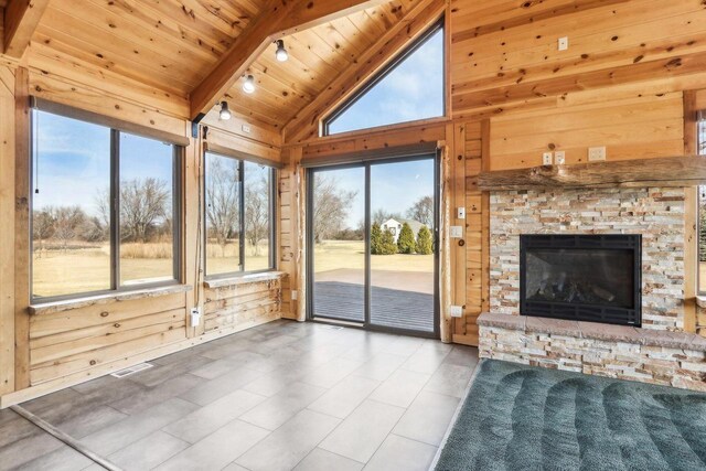 10728 Spring St, Mount Pleasant, WI 53177 - unfurnished living room featuring visible vents, lofted ceiling with beams, wooden walls, a stone fireplace, and wooden ceiling