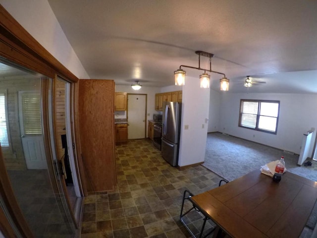 N2798 Little Green Rd, Markesan, WI 53946 - kitchen with range, ceiling fan, brown cabinets, dark carpet, and freestanding refrigerator