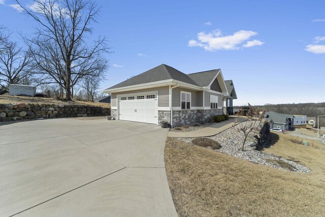 301 Church St, Barneveld, WI 53507 - view of side of property with stone siding, concrete driveway, a garage, and a shingled roof