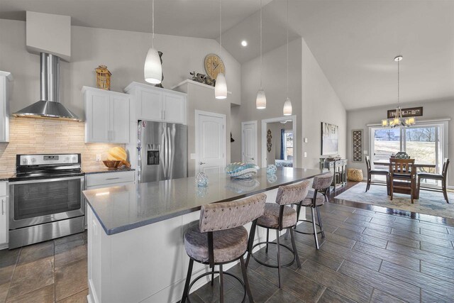 301 Church St, Barneveld, WI 53507 - kitchen featuring a breakfast bar area, stainless steel appliances, white cabinets, backsplash, and a center island