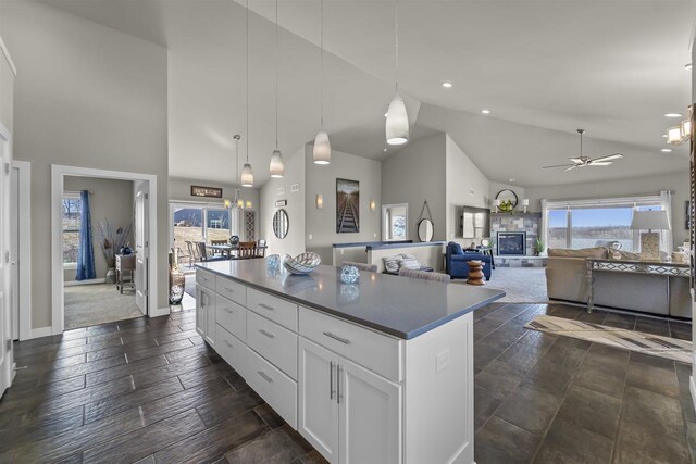301 Church St, Barneveld, WI 53507 - kitchen featuring high vaulted ceiling, pendant lighting, a kitchen island, white cabinets, and ceiling fan