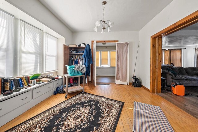 interior space featuring baseboards, a chandelier, and light wood finished floors