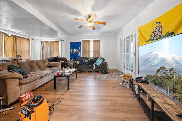 living area with a textured ceiling, a ceiling fan, and wood finished floors