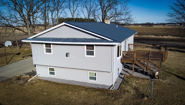 W11829 Buss Ln, Waterloo, WI 53594 - view of home's exterior featuring a deck, a chimney, a shingled roof, a lawn, and stairway