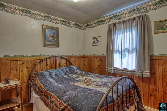 9293 N County Hwy E, Hayward, WI 54843 - bedroom with a wainscoted wall and wood walls