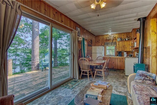 9293 N County Hwy E, Hayward, WI 54843 - dining area with a wood stove, plenty of natural light, a ceiling fan, and wood walls