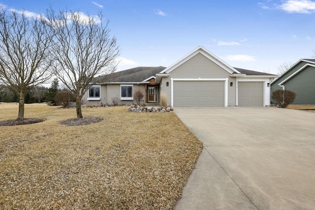 single story home featuring a front yard, an attached garage, and driveway
