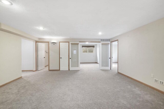 unfurnished room featuring visible vents, recessed lighting, light colored carpet, and baseboards
