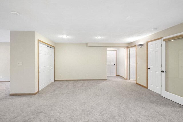 finished basement with light colored carpet and baseboards
