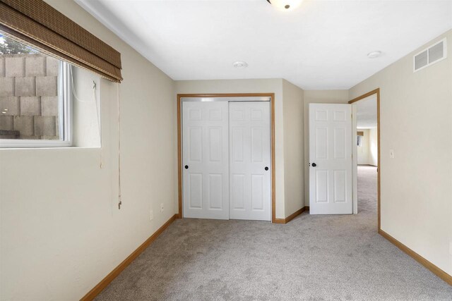 unfurnished bedroom with a closet, baseboards, visible vents, and carpet floors
