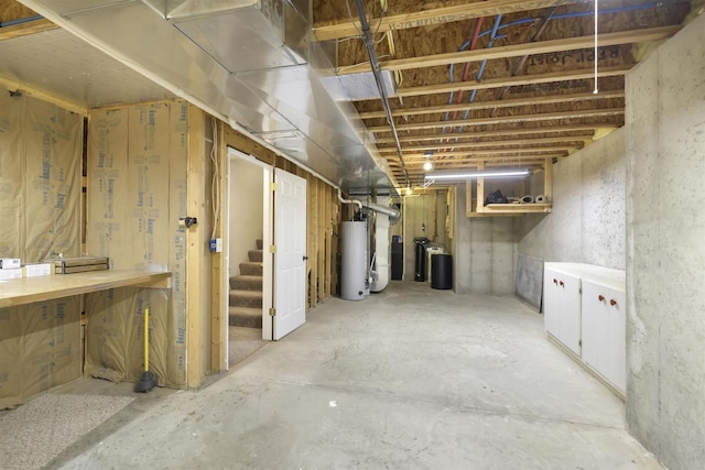 unfinished below grade area featuring gas water heater and stairs