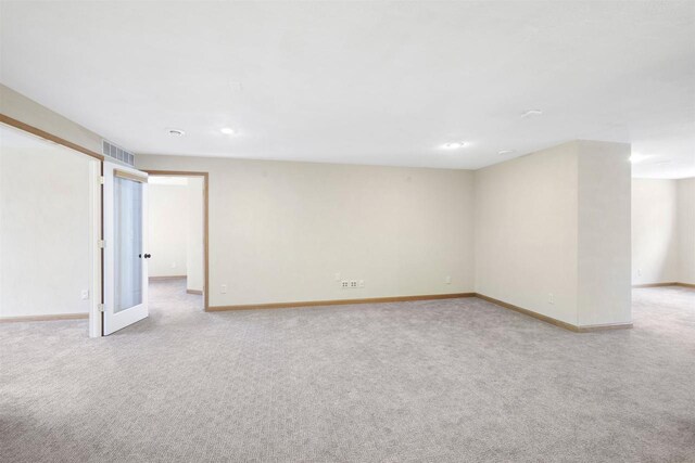 finished basement featuring light carpet, visible vents, and baseboards