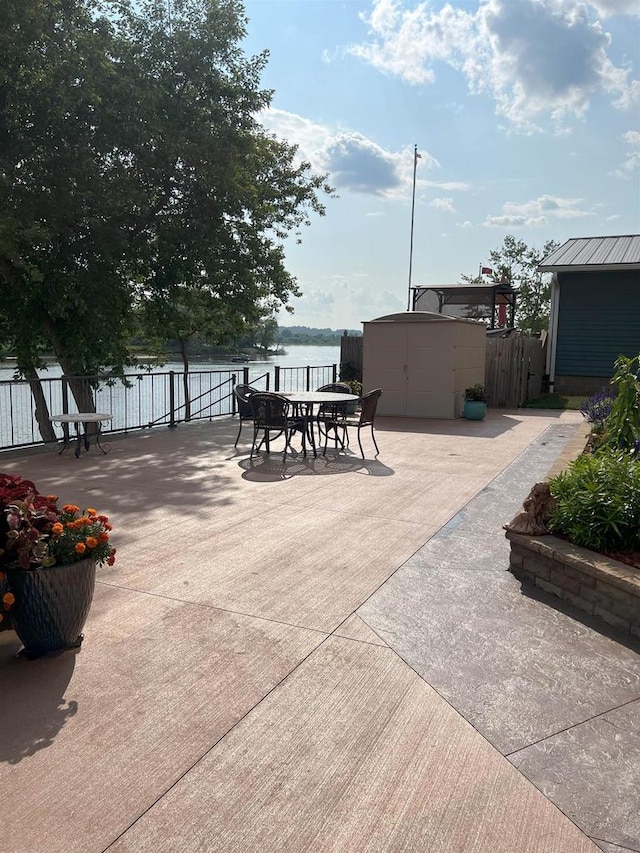 1300 Jack Oak Rd, Cassville, WI 53806 - view of patio / terrace featuring an outbuilding, a storage shed, fence, and a water view