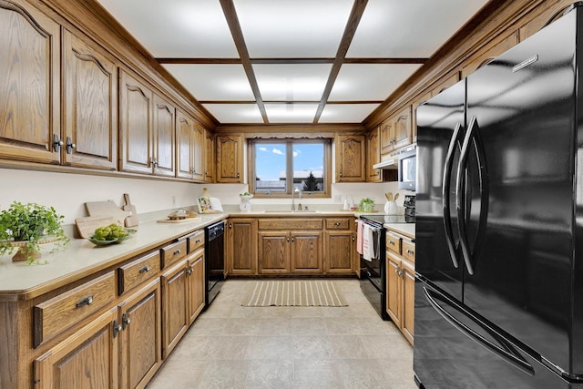 2721 Powder Hill Rd, Slinger, WI 53086 - kitchen featuring a sink, black appliances, brown cabinetry, and light countertops