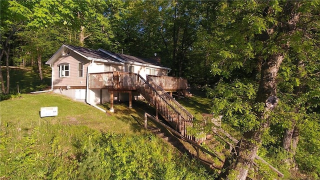 2897 Indian Mound Rd, Luck, WI 54853 - rear view of property with a deck, a lawn, stairs, and a view of trees