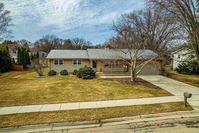 ranch-style home featuring a front lawn, a garage, and driveway