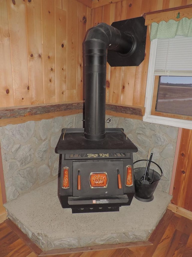 interior details with wood finished floors and a wood stove