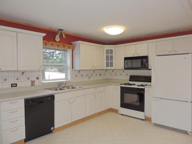 kitchen featuring a sink, tasteful backsplash, black appliances, and white cabinets