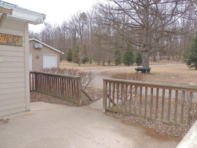 view of patio with a detached garage and driveway