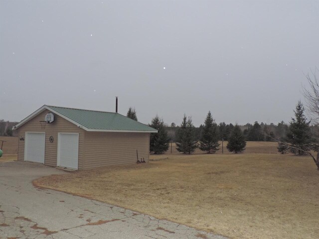 view of yard with a detached garage and an outdoor structure