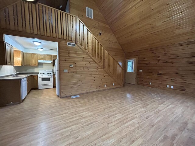 615 Sandy Beach Ct, Warrens, Warrens, WI 54666 - kitchen with visible vents, under cabinet range hood, open floor plan, white appliances, and wood walls