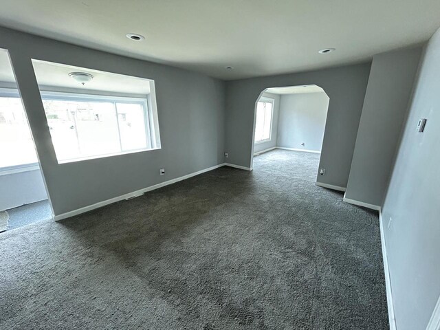 6082 N 36th St, Milwaukee, WI 53209 - empty room with arched walkways, baseboards, dark colored carpet, and recessed lighting