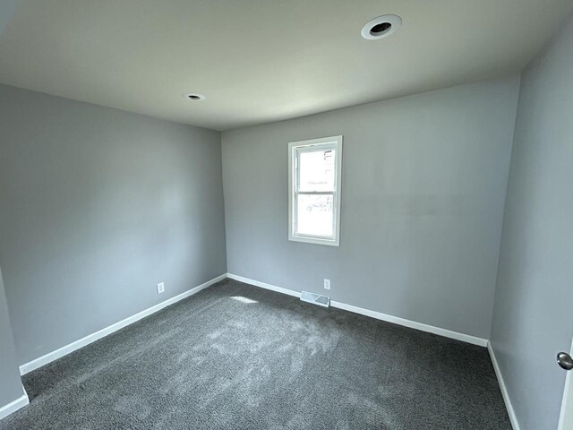 6082 N 36th St, Milwaukee, WI 53209 - unfurnished room with baseboards, visible vents, and dark colored carpet