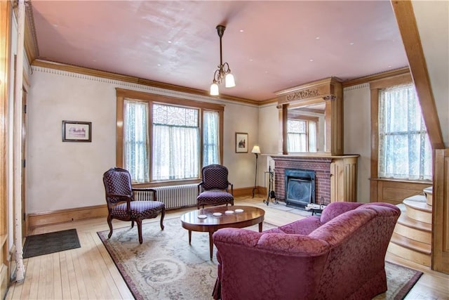 435 Jefferson St, Eau Claire, WI 54701 - living room with radiator heating unit, ornamental molding, a fireplace, baseboards, and light wood-style floors