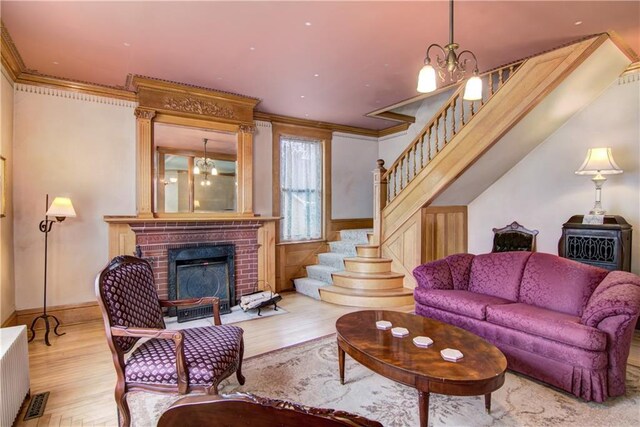 435 Jefferson St, Eau Claire, WI 54701 - living room with a chandelier, stairs, ornamental molding, wood finished floors, and a brick fireplace