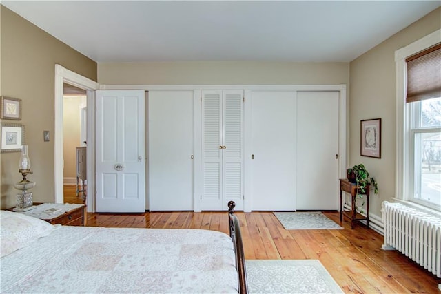435 Jefferson St, Eau Claire, WI 54701 - bedroom with radiator, wood-type flooring, and two closets