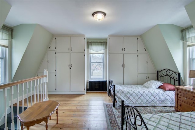 435 Jefferson St, Eau Claire, WI 54701 - bedroom with radiator heating unit, light wood finished floors, lofted ceiling, and multiple closets