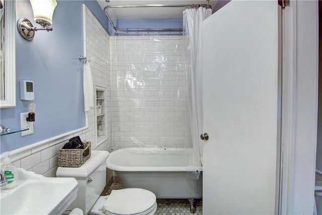 435 Jefferson St, Eau Claire, WI 54701 - bathroom featuring toilet, tile walls, a sink, shower / tub combo, and a wainscoted wall